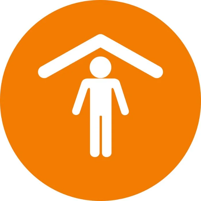 Shelter icon Person icon standing beneath a stylized roof inside an orange circular badge